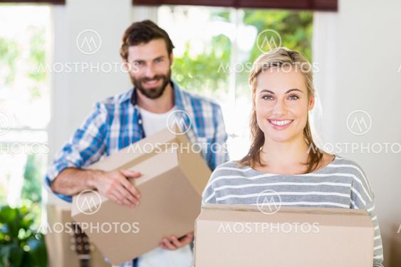 Portrait of young couple holding cardboard boxes