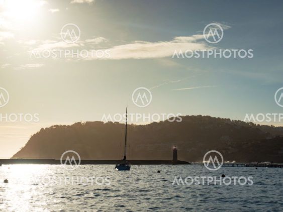 Beautiful white yacht on calm sea at lighthouse
