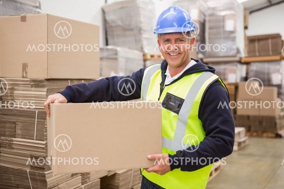 Worker carrying box in warehouse