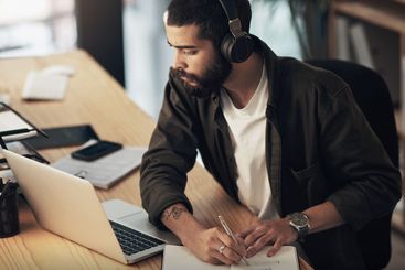 Creative, man and thinking with laptop, notebook and...