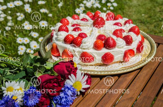 Summer flowers at a table with a homemade strawberry cake