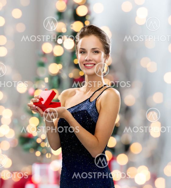 smiling woman in evening dress with red gift box