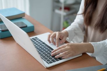 Asian woman using laptop to study student engaged in...