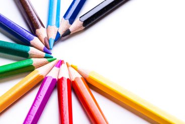 Colorful pencils arranged in a circular pattern on a...