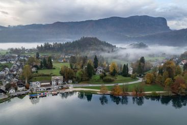Lake Bled valley embraced by fog during fall foliage season