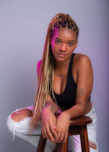 Brunette model with braids in her hair, wearing white...