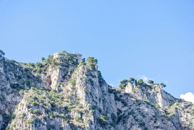 Daylight view to rock mountains with green trees and old...