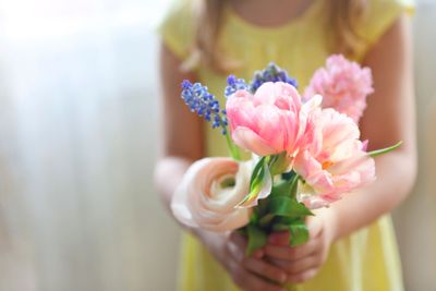 Little girl with bouquet of spring flowers