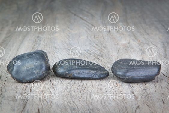 Round stones on wooden texture for a spa.