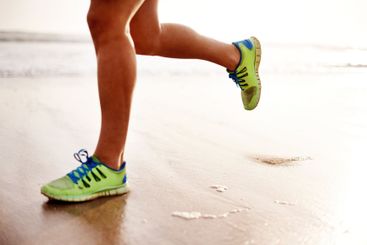 Man, sand and shoes running on beach for fitness,...