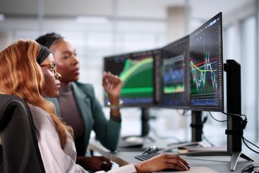 Young African American businesswoman analyzing stock...