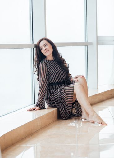 Beautiful fashionable brunette woman sitting at a...