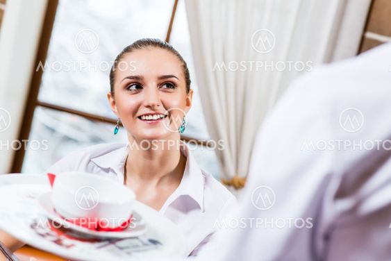 waiter brings a dish for a nice woman
