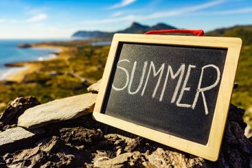 Black board with word summer against sea coast
