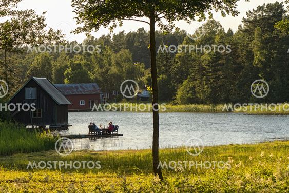 People sitting on a pier at sunset and eat dinner