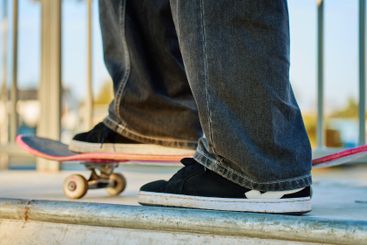 Skateboarder riding on pink skateboard at skatepark
