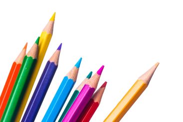 Brightly colored pencils arranged in a row on a white...