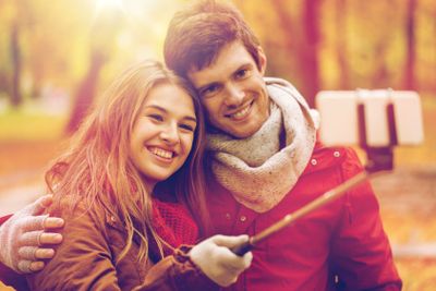 couple taking selfie by smartphone in autumn park