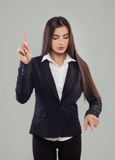 Brunette woman in black suit and white shirt pushing...