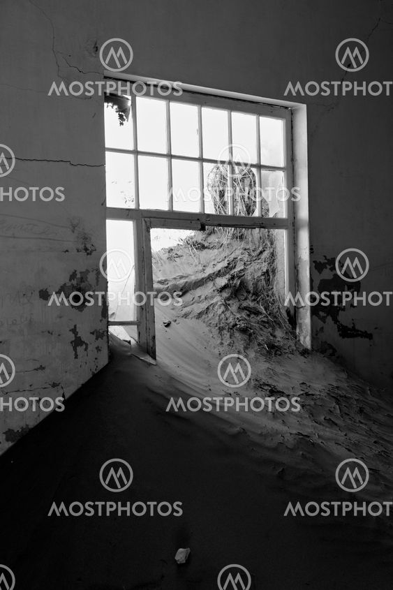 a dune coming from a window in a house at kolmanskop ghost town namibia africa