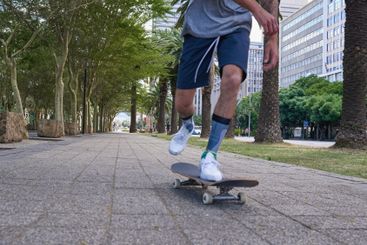 Skateboard, feet and urban with man in city for culture,...