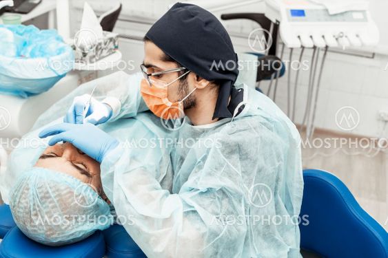 A young male dentist doctor treats a patient. Medical...