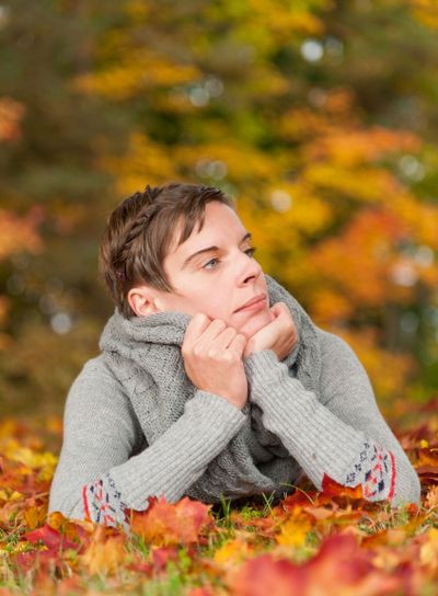 Young woman lying on autumnal leaves