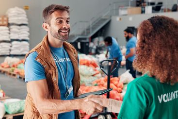 Handshake, happy and volunteers for non profit at food...