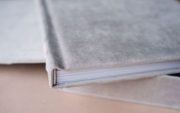 A photo book in a grey cloth cover lies on the box. the...