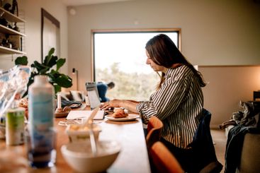 Side view of businesswoman working on laptop at home