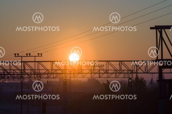 Sun rising on frosty morning over industrial area