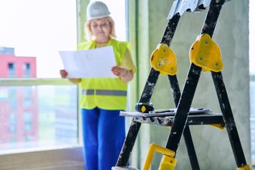 Close-up of construction tools, female industrial worker...