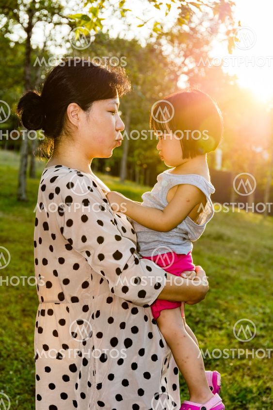 Asian mother kissing baby