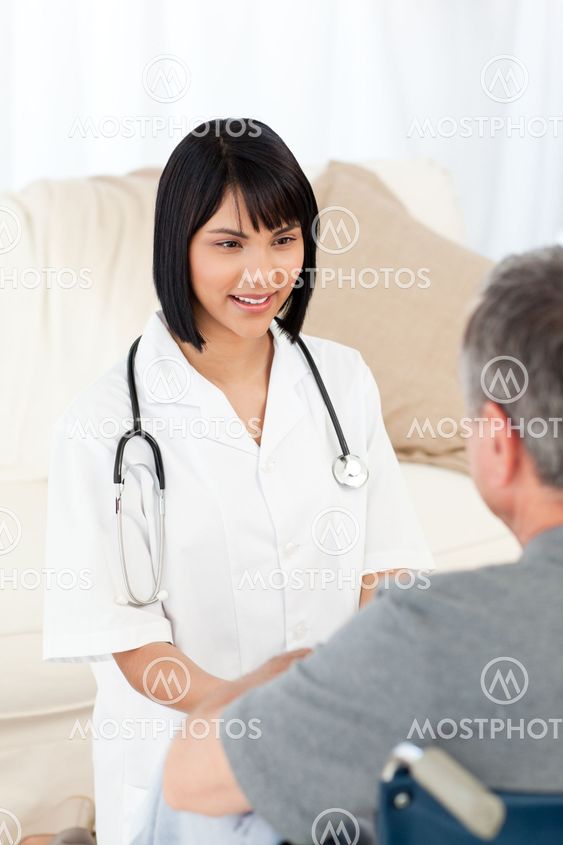 Man in his wheelchair with his nurse at home