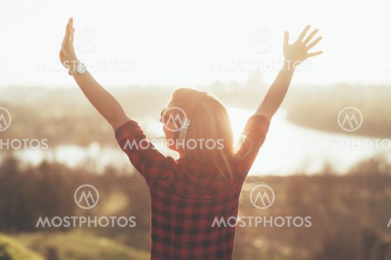 Young woman listening to the music on headphones outdoors