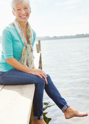 Senior woman, lake and jetty with smile, water and relax...