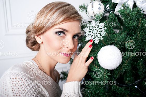 The young girl decorates a New Year Christmas tree