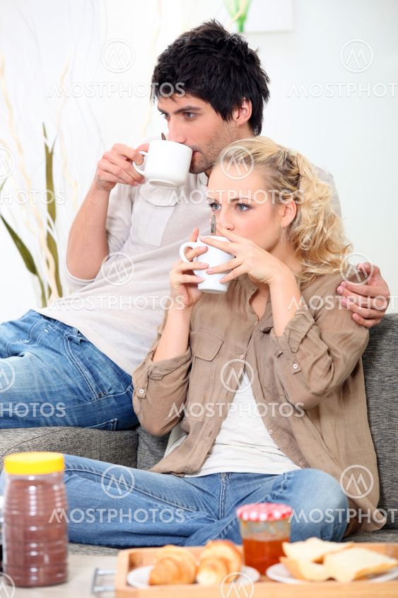 Couple having breakfast on the couch