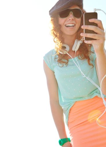 Woman, outdoor and phone for music on headphones,...