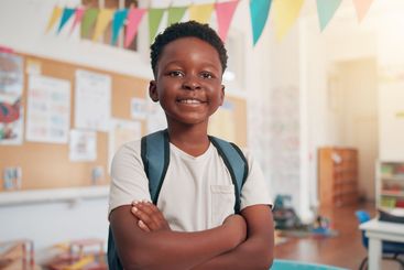 Arms crossed, happy and education with black boy in...