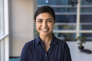 Happy beautiful Indian businesswoman looking at camera