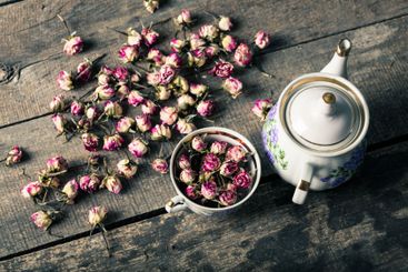 Vintage teapot and cup with blooming tea flowers on...