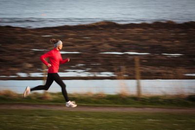 Young woman on her evening jog along the seacoast