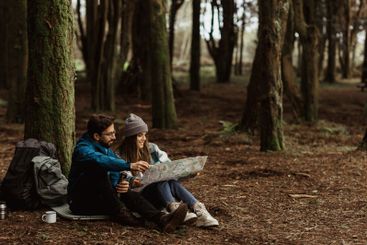 Smiling young european man and woman tourists in jackets...