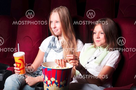 Two young girls watching in cinema